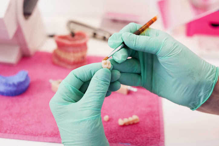 Technik dentystyczny pracujący nad koroną zęba